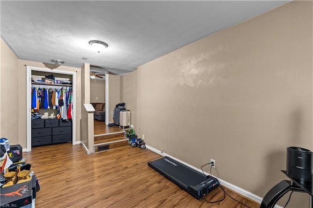 exercise area with light hardwood / wood-style floors and ceiling fan