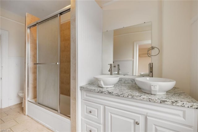 full bathroom featuring toilet, vanity, and bath / shower combo with glass door