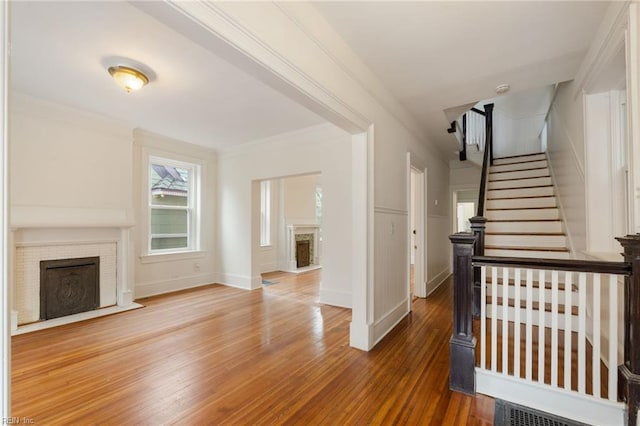 stairs featuring hardwood / wood-style flooring and ornamental molding