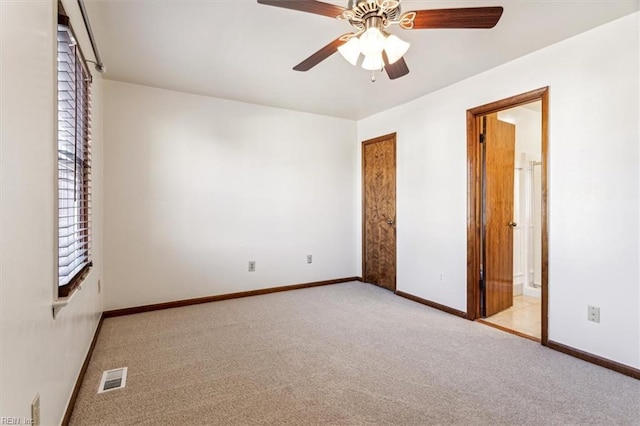 unfurnished bedroom with ceiling fan, connected bathroom, and light carpet