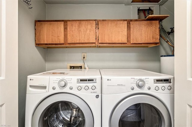 clothes washing area featuring cabinets and washer and dryer