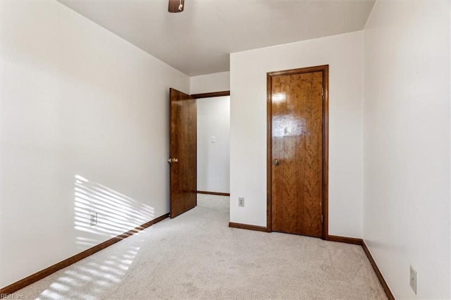 unfurnished bedroom featuring light colored carpet and ceiling fan