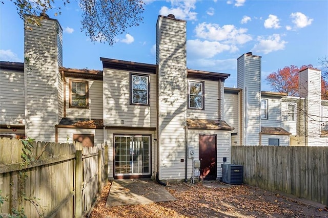 rear view of property with central AC