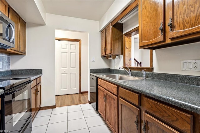 kitchen featuring tasteful backsplash, sink, light tile patterned floors, and stainless steel appliances