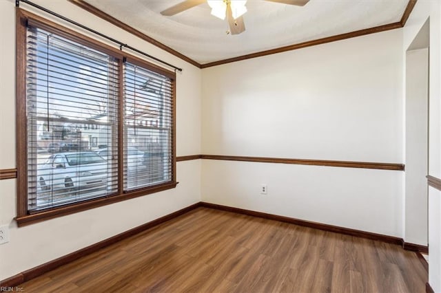 spare room with crown molding, dark wood-type flooring, and ceiling fan