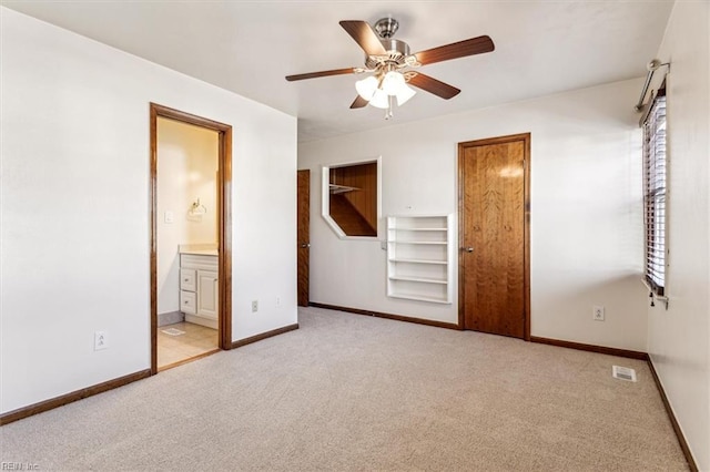 unfurnished bedroom with light carpet, ensuite bath, and ceiling fan