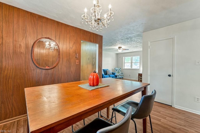 dining area featuring a chandelier, light hardwood / wood-style flooring, and a textured ceiling