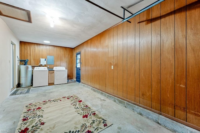 basement featuring wooden walls and washing machine and clothes dryer