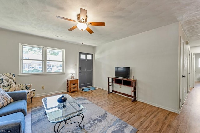 living room with light hardwood / wood-style flooring and ceiling fan