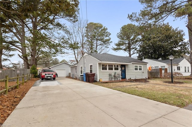 view of front of home featuring a garage, an outdoor structure, and a front lawn