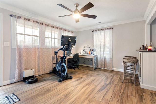 exercise area with hardwood / wood-style floors, ornamental molding, and ceiling fan