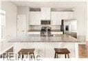 kitchen featuring a breakfast bar area and white cabinets