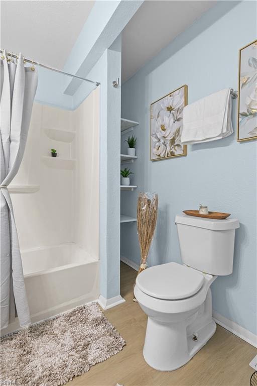 bathroom with wood-type flooring, shower / bath combination with curtain, and toilet