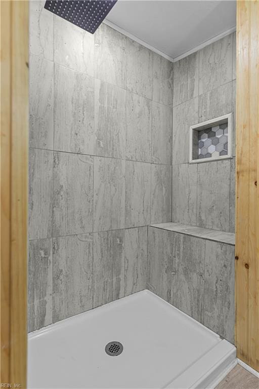 bathroom featuring ornamental molding and a shower