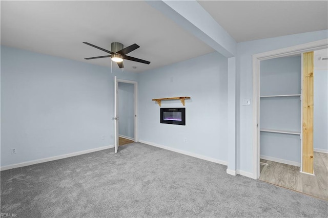 unfurnished bedroom with beamed ceiling, carpet floors, a closet, and ceiling fan