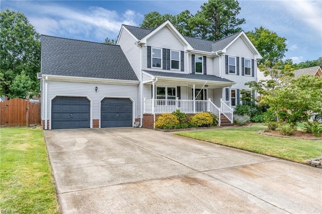 view of property featuring a garage, a front lawn, and covered porch