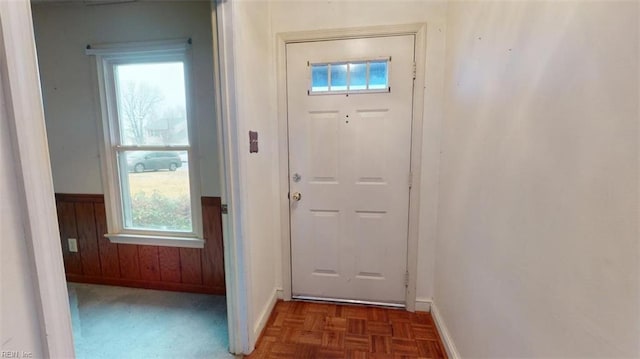 entryway featuring wooden walls and wainscoting