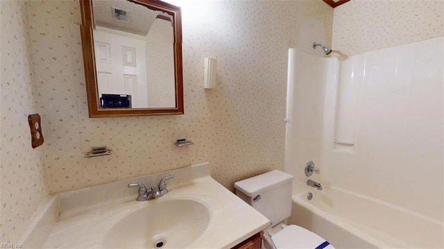 bathroom with bathtub / shower combination, toilet, visible vents, vanity, and wallpapered walls