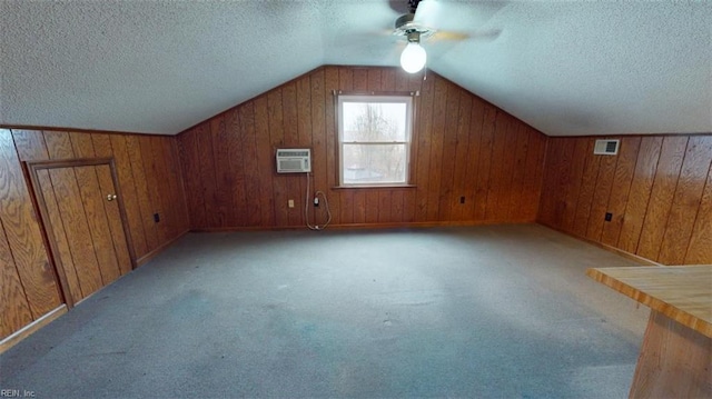 bonus room with a textured ceiling, light carpet, visible vents, vaulted ceiling, and an AC wall unit