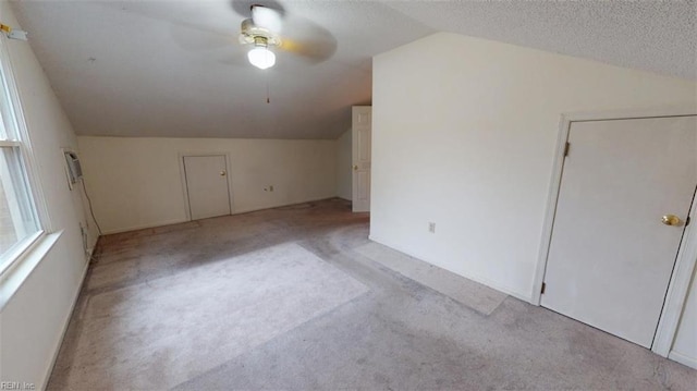 bonus room with lofted ceiling, a ceiling fan, carpet floors, and a textured ceiling