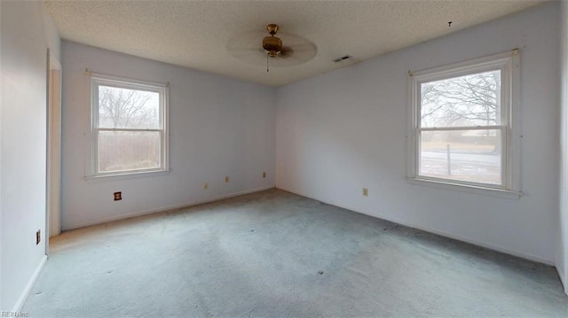 unfurnished room with a textured ceiling, a ceiling fan, and light colored carpet