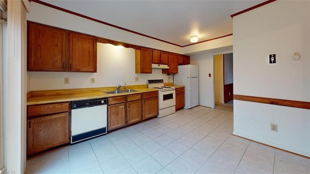 kitchen featuring under cabinet range hood, white appliances, a sink, light countertops, and brown cabinets