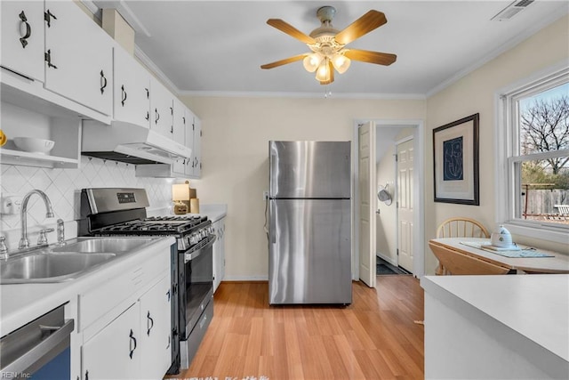 kitchen featuring white cabinetry, ornamental molding, appliances with stainless steel finishes, and sink