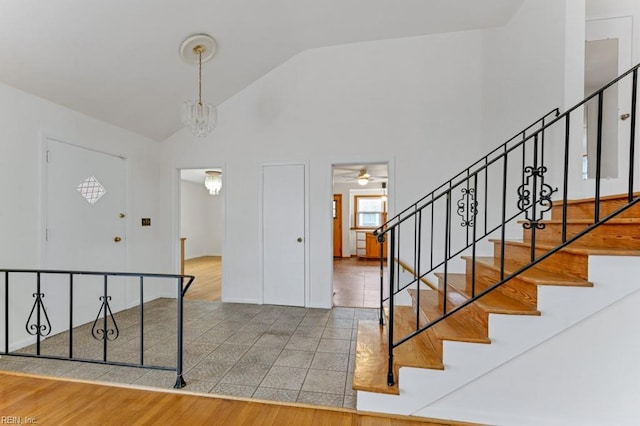 entryway with high vaulted ceiling, a chandelier, and hardwood / wood-style floors