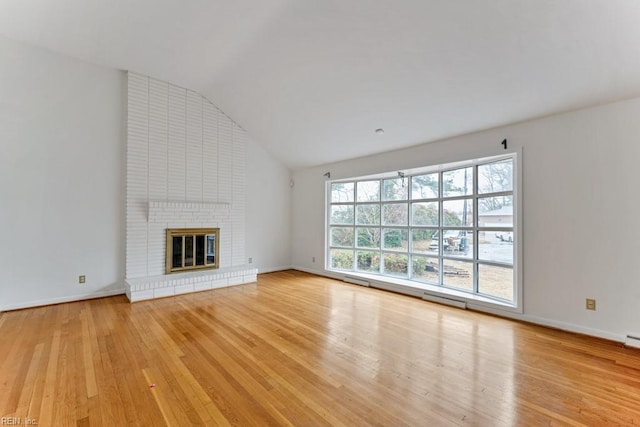 unfurnished living room featuring lofted ceiling, a fireplace, and light hardwood / wood-style flooring