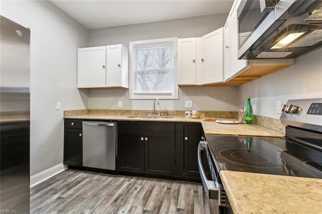 kitchen featuring sink, light hardwood / wood-style flooring, stainless steel appliances, and white cabinets