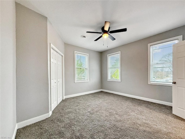 unfurnished bedroom with carpet floors, ceiling fan, and a closet