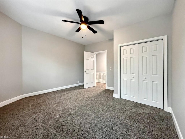 unfurnished bedroom with dark colored carpet, ceiling fan, and a closet