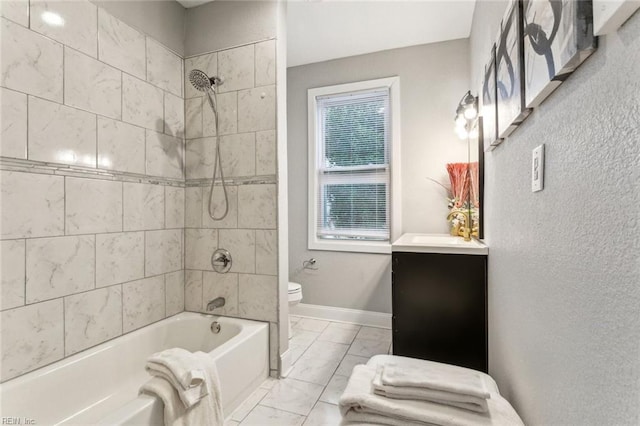 full bathroom with tiled shower / bath, vanity, and toilet