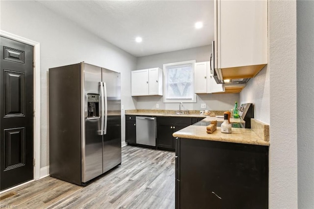 kitchen featuring stainless steel appliances, sink, white cabinets, and light hardwood / wood-style flooring