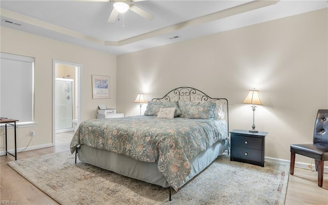 bedroom with wood-type flooring and a raised ceiling