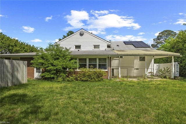 37 Lancaster Ter, Hampton, VA 23666 - rear view of property with a yard, roof mounted solar panels, fence, and brick siding