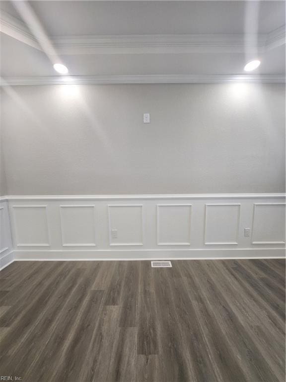 spare room with dark wood-type flooring and ornamental molding