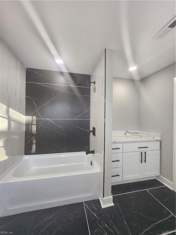 bathroom featuring vanity and tiled shower / bath combo