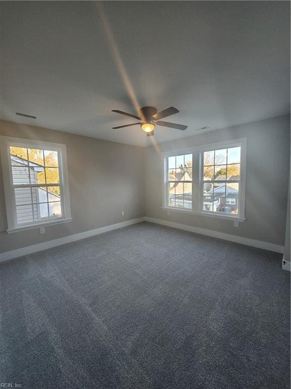 carpeted empty room with ceiling fan and a healthy amount of sunlight