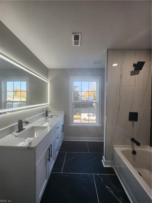 bathroom with tiled shower / bath combo and vanity