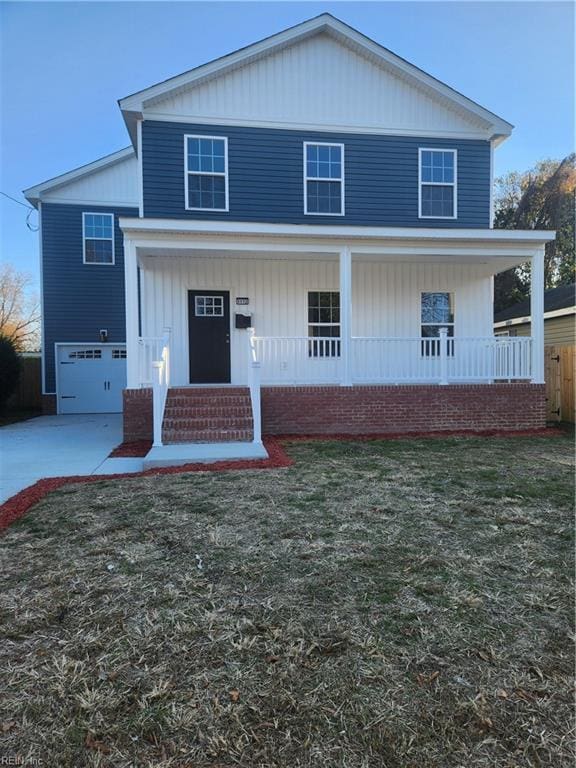 view of property featuring a garage, a front yard, and a porch