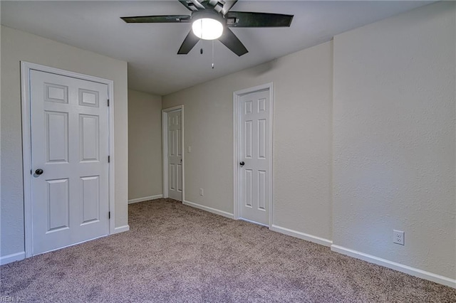 unfurnished bedroom with ceiling fan and light colored carpet