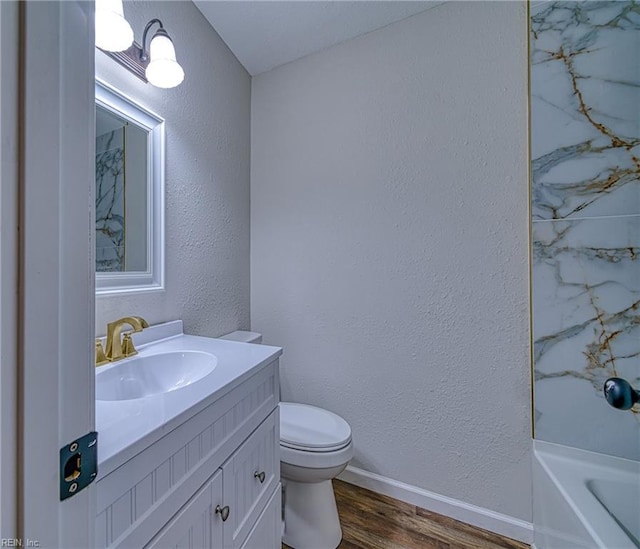 bathroom featuring vanity, toilet, hardwood / wood-style floors, and a bath