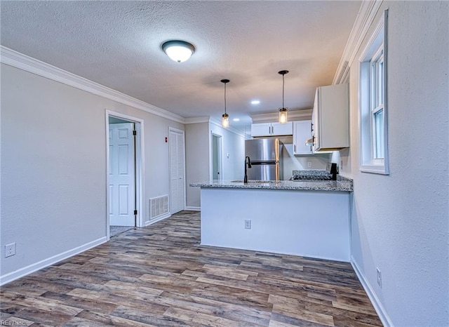 kitchen with pendant lighting, dark wood-type flooring, stainless steel refrigerator, white cabinets, and kitchen peninsula