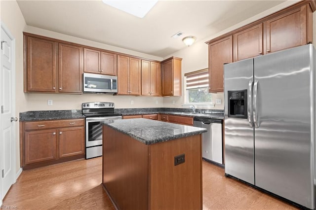 kitchen featuring sink, light hardwood / wood-style flooring, stainless steel appliances, and a center island