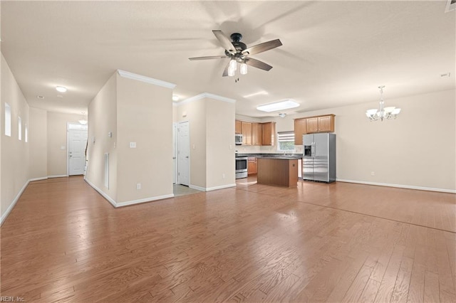 unfurnished living room with hardwood / wood-style flooring, ceiling fan with notable chandelier, and ornamental molding