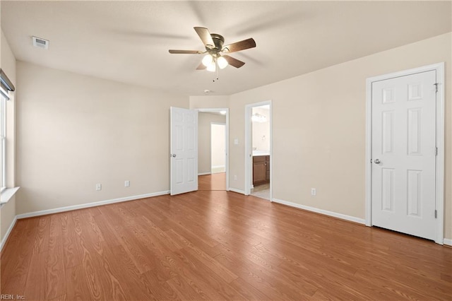 unfurnished bedroom with ceiling fan, ensuite bath, and light hardwood / wood-style flooring