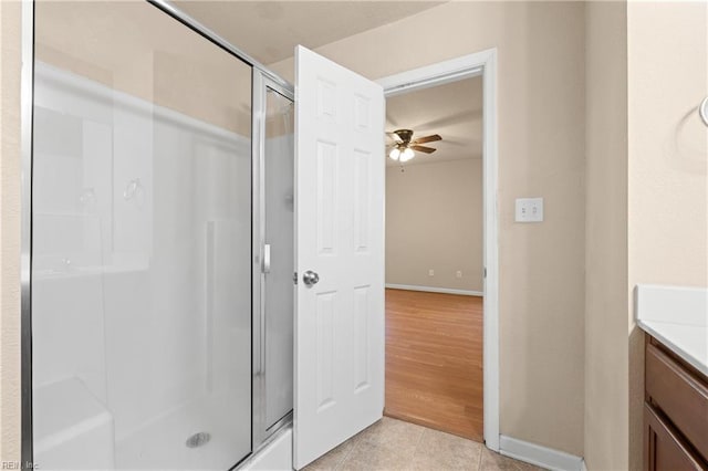 bathroom featuring ceiling fan, tile patterned floors, a shower with door, and vanity