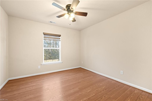 empty room with ceiling fan and light hardwood / wood-style flooring