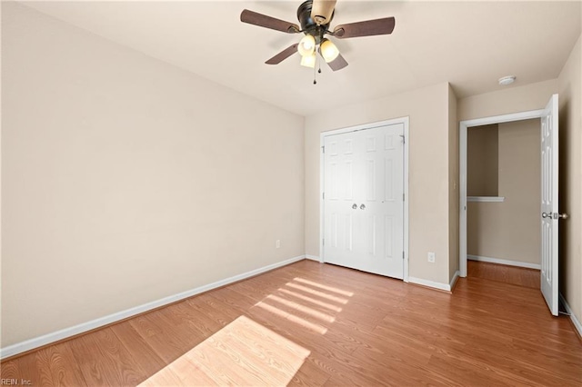 unfurnished bedroom featuring hardwood / wood-style floors, ceiling fan, and a closet